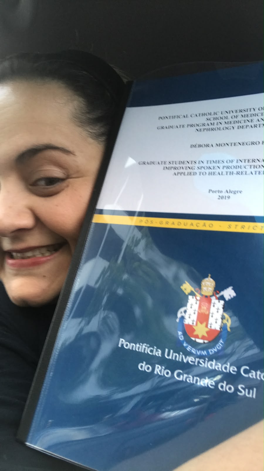 Prof.ª Dr.ª Débora Pasin com o exemplar impresso da tese de doutorado em Medicina da PUCRS
